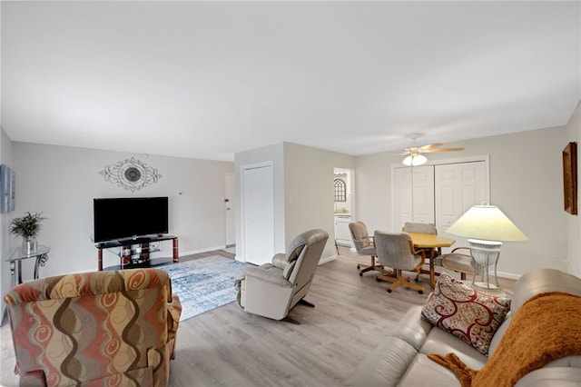 living room with ceiling fan and light hardwood / wood-style floors