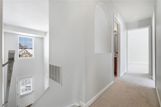 hall featuring light colored carpet