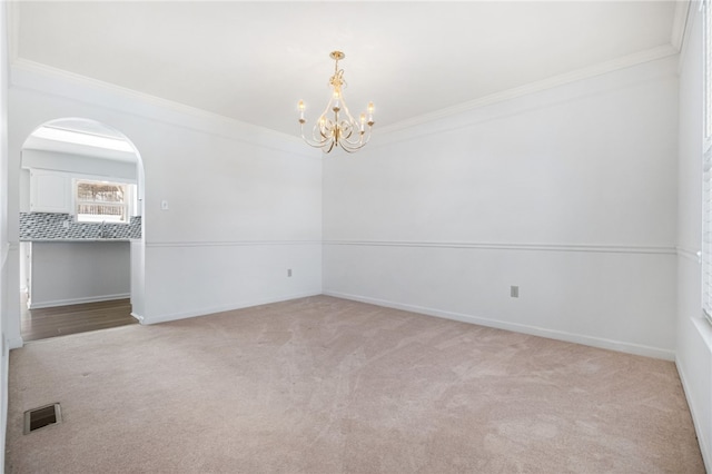 empty room with crown molding, light colored carpet, and a notable chandelier