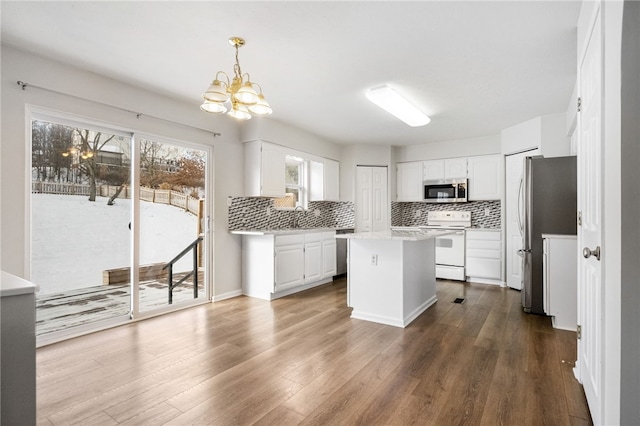 kitchen with stainless steel appliances, hanging light fixtures, a kitchen island, and white cabinets