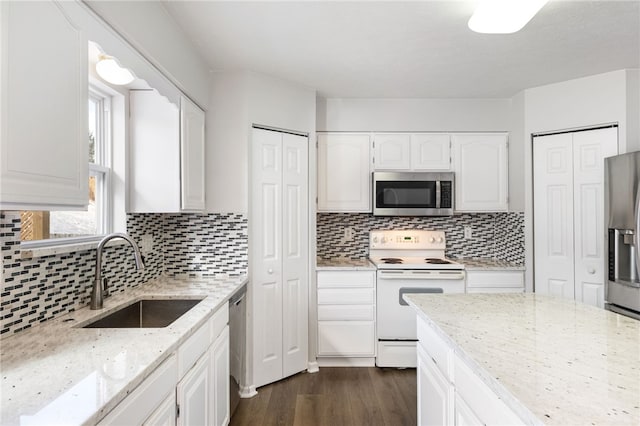 kitchen featuring light stone countertops, white cabinetry, appliances with stainless steel finishes, and sink