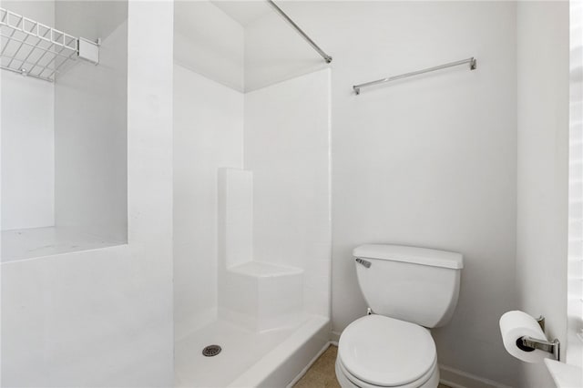 bathroom featuring a shower and toilet