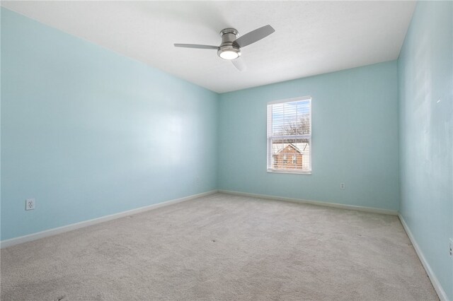 carpeted spare room with ceiling fan