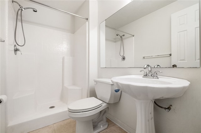 bathroom featuring tile patterned floors, toilet, and walk in shower