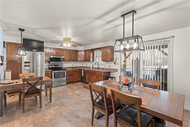 kitchen with sink, decorative light fixtures, ceiling fan, and appliances with stainless steel finishes