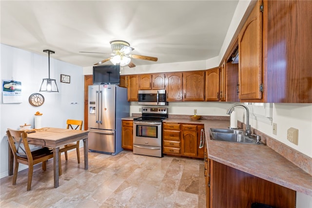 kitchen featuring appliances with stainless steel finishes, sink, ceiling fan, and decorative light fixtures