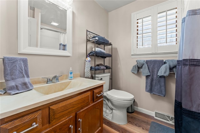 bathroom featuring vanity, hardwood / wood-style floors, and toilet