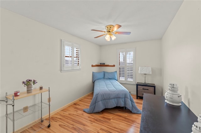 bedroom featuring multiple windows, wood-type flooring, and ceiling fan