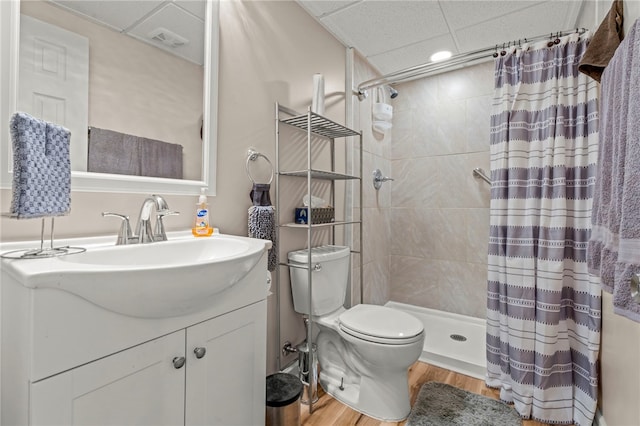 bathroom featuring toilet, a paneled ceiling, vanity, a shower with shower curtain, and hardwood / wood-style floors