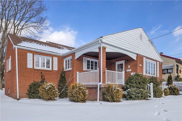 view of snow covered exterior featuring a porch