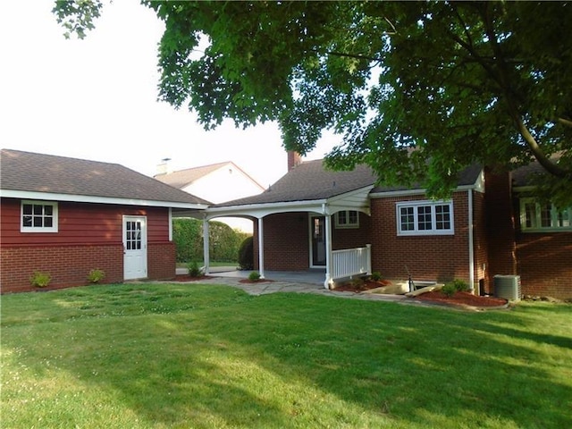 rear view of house with a yard and central AC unit