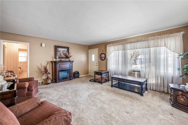 living area featuring carpet, a glass covered fireplace, and visible vents