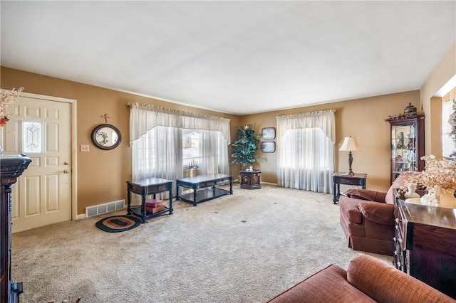 living room featuring carpet floors, visible vents, and baseboards