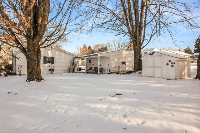 snow covered house with a storage shed