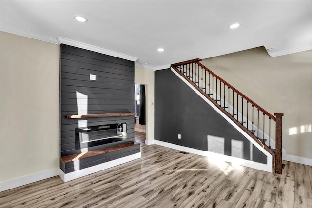 unfurnished living room with crown molding and hardwood / wood-style floors