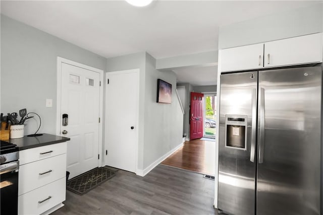 kitchen featuring appliances with stainless steel finishes, dark hardwood / wood-style flooring, and white cabinetry