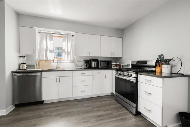 kitchen featuring white cabinets, appliances with stainless steel finishes, sink, and dark hardwood / wood-style floors