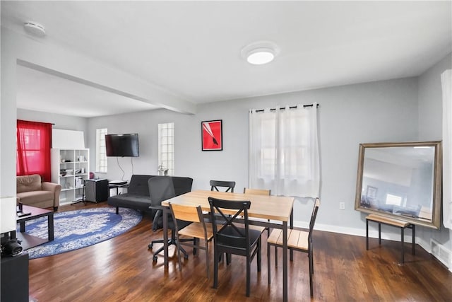 dining room with dark hardwood / wood-style floors and beamed ceiling