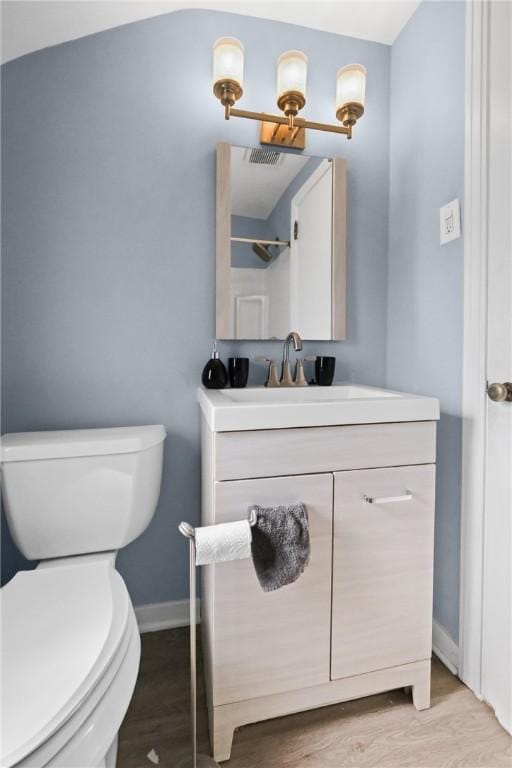 bathroom featuring toilet, hardwood / wood-style flooring, and vanity