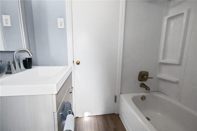 bathroom featuring hardwood / wood-style floors, vanity, and bathing tub / shower combination