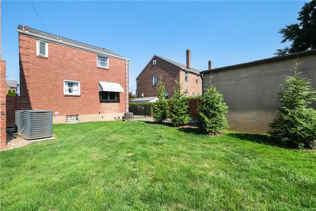 rear view of house with a lawn and cooling unit