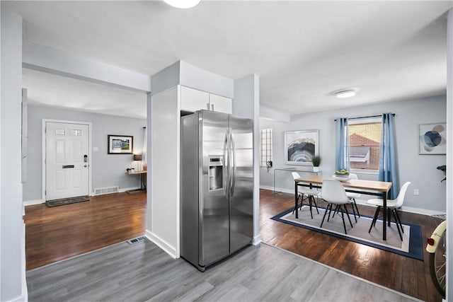 kitchen featuring white cabinetry, stainless steel fridge with ice dispenser, and wood-type flooring