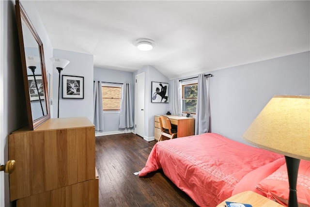 bedroom with dark wood-type flooring, multiple windows, and lofted ceiling