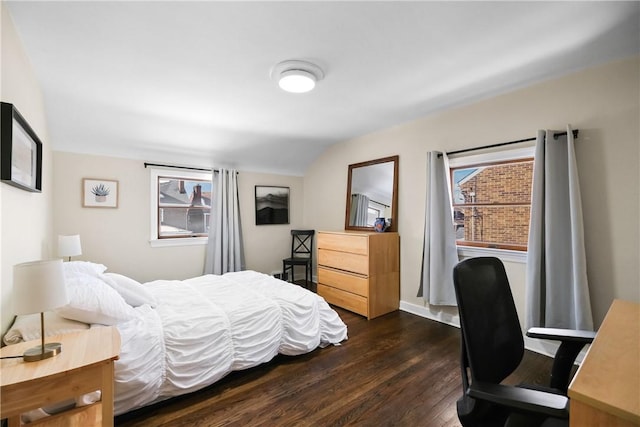 bedroom with vaulted ceiling, dark hardwood / wood-style floors, and multiple windows