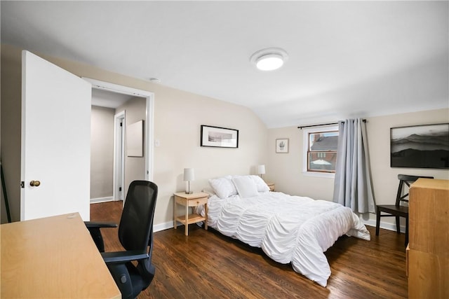 bedroom with vaulted ceiling and dark hardwood / wood-style flooring