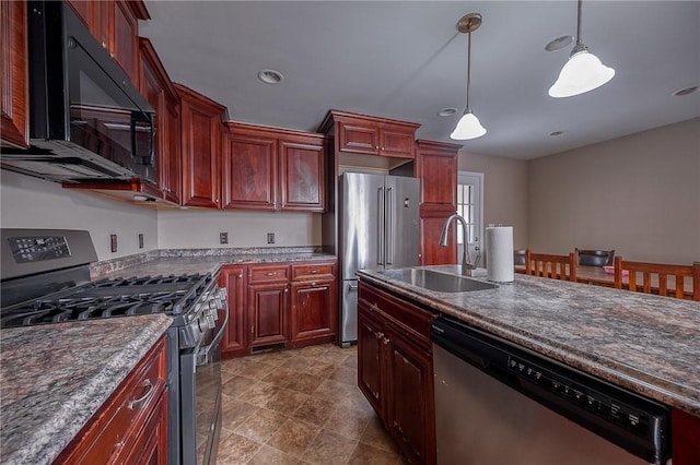 kitchen featuring stainless steel appliances, hanging light fixtures, and sink