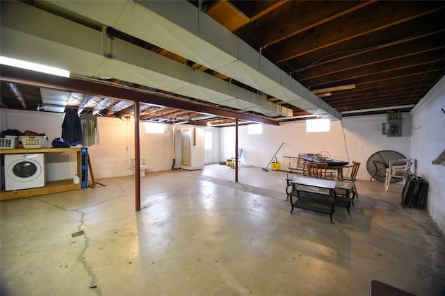 basement with electric panel and washer / dryer