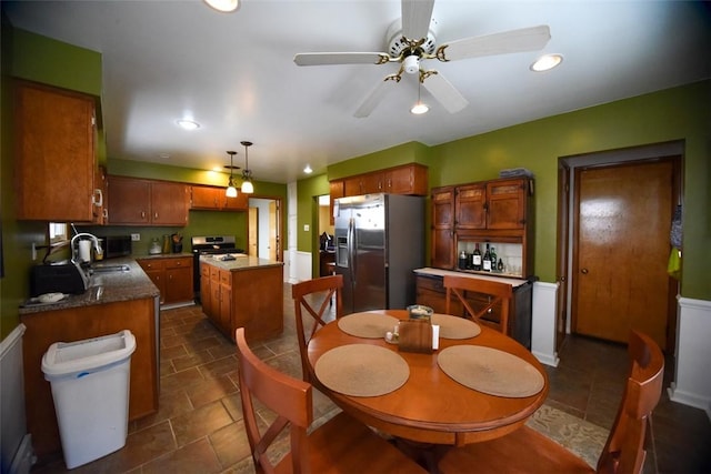 dining space featuring ceiling fan and sink