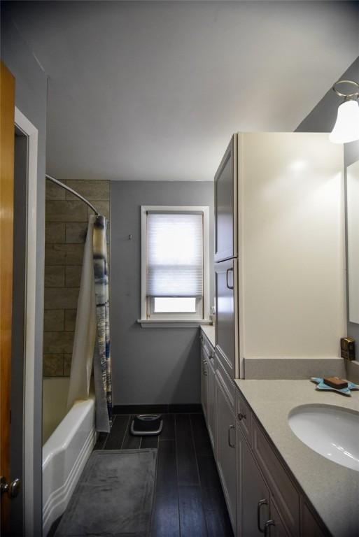 bathroom featuring ceiling fan, shower / bathtub combination with curtain, and vanity