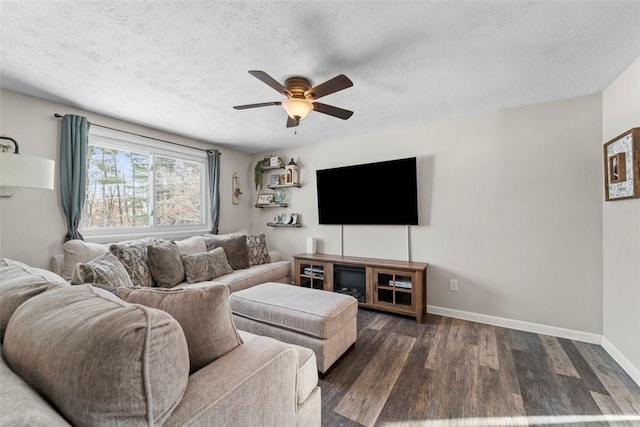 living room featuring ceiling fan, dark hardwood / wood-style floors, and a textured ceiling