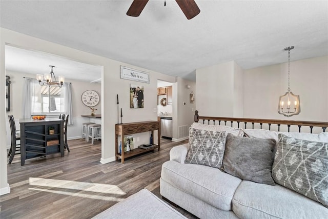 living room featuring ceiling fan with notable chandelier and hardwood / wood-style flooring