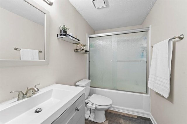 full bathroom with toilet, hardwood / wood-style floors, a textured ceiling, vanity, and shower / bath combination with glass door