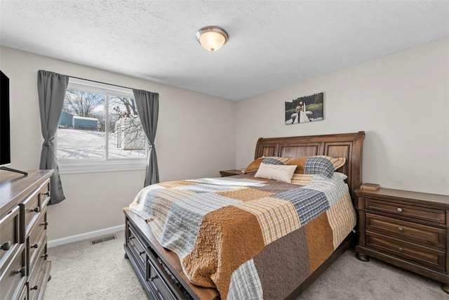 bedroom featuring a textured ceiling and light colored carpet