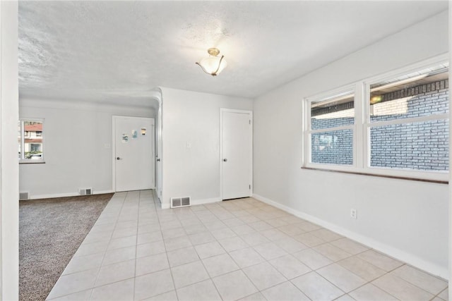 carpeted spare room featuring a textured ceiling