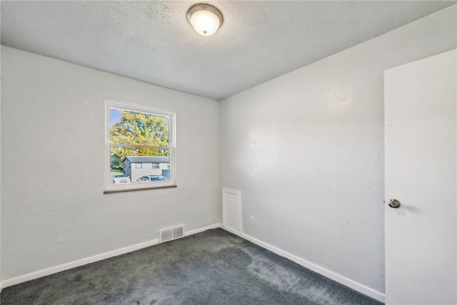 empty room featuring dark colored carpet