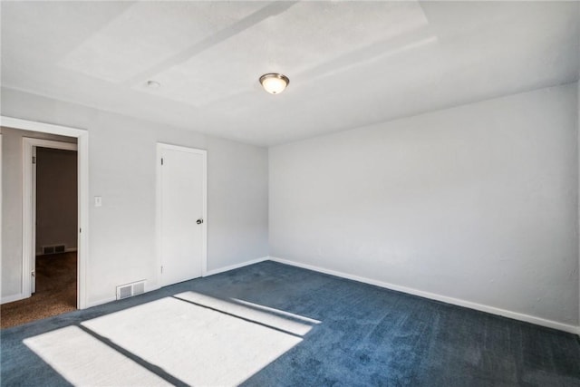 spare room with dark colored carpet