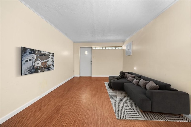 living room featuring a textured ceiling, ornamental molding, and hardwood / wood-style floors