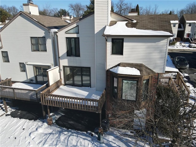 snow covered property featuring a wooden deck