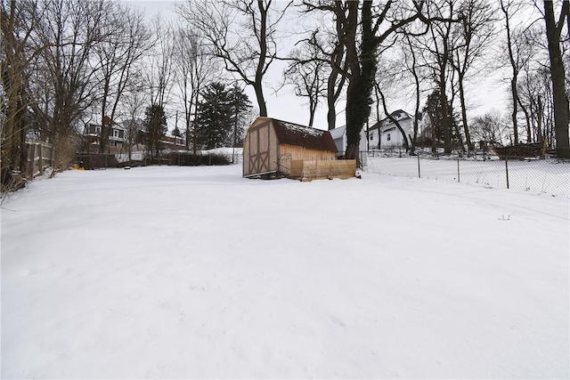 yard layered in snow with a shed