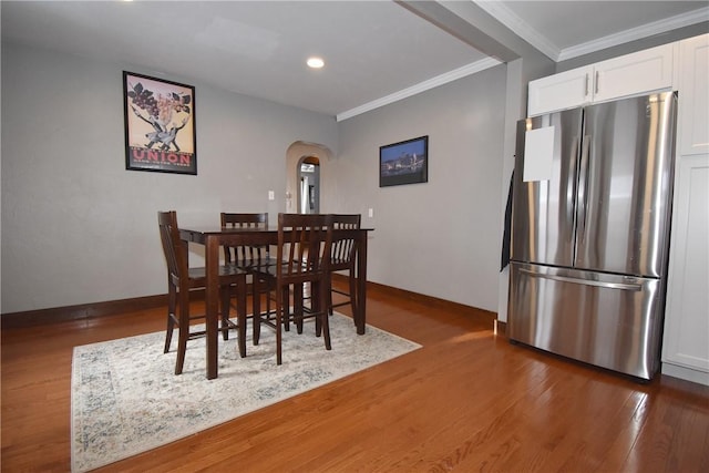 dining space featuring dark hardwood / wood-style flooring and crown molding