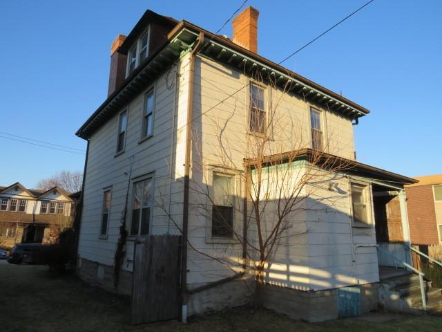 back of house with a chimney