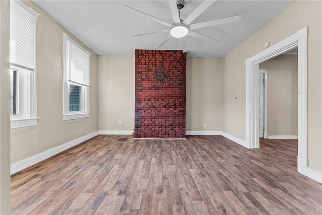 unfurnished living room featuring ceiling fan, a wealth of natural light, and wood-type flooring