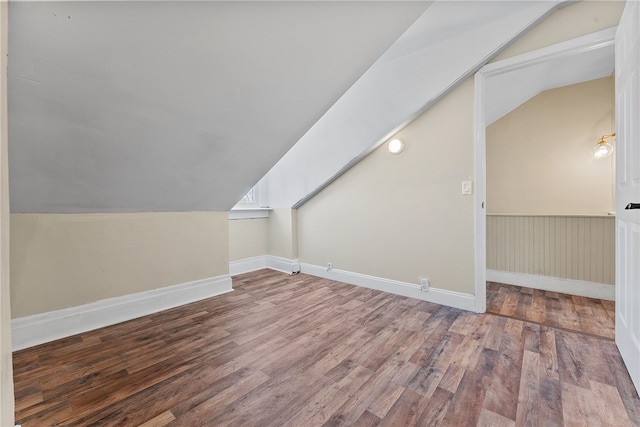 additional living space with wood-type flooring and lofted ceiling