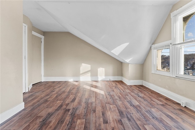 bonus room with dark wood-type flooring and lofted ceiling