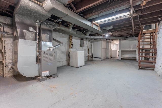 basement featuring electric panel, heating unit, and washer / dryer