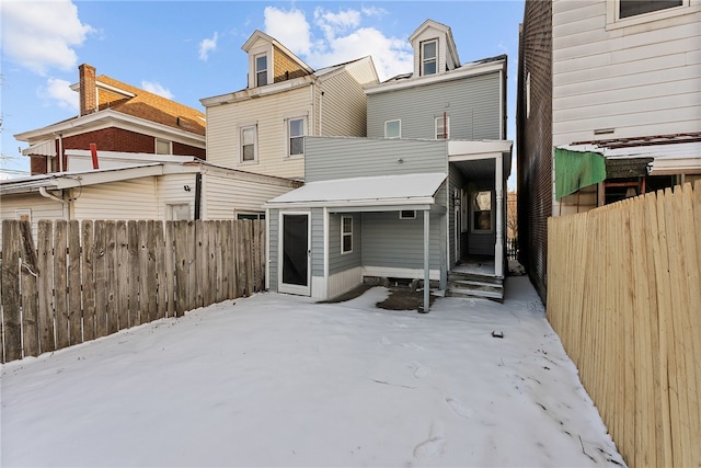 view of snow covered rear of property